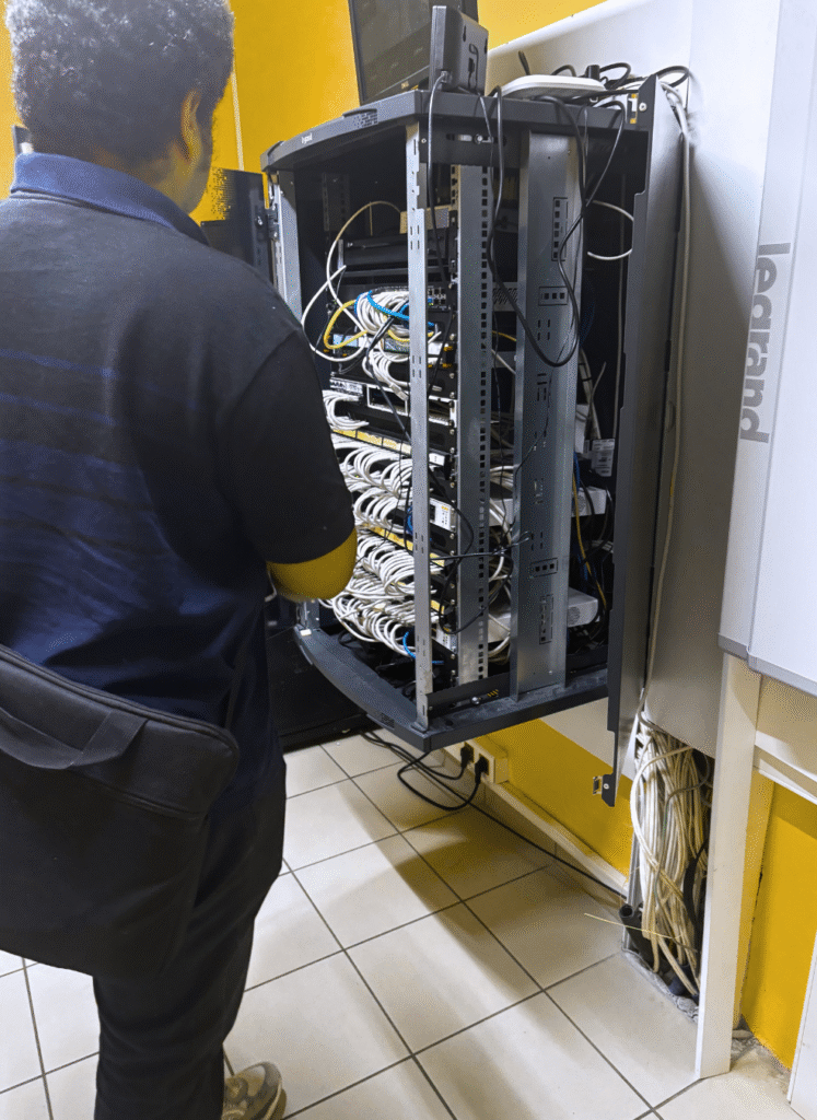 Technicien v&eacute;rifiant le c&acirc;blage d'un serveur informatique.