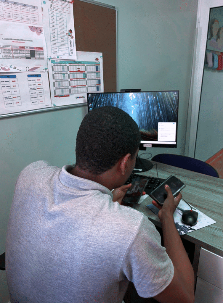 Homme travaillant avec ordinateur et téléphones.